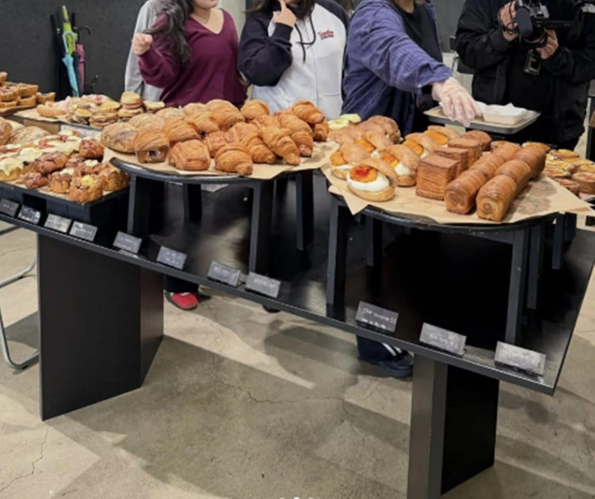 빵 진열대 앞에서 빵을 고르는 촬영 동행자들의 모습