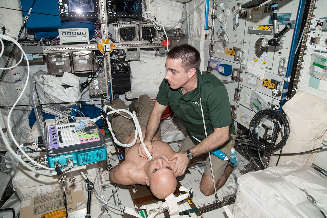 우주정거장에서 캐시디가 파르미타노의 몸에 초음파 탐촉자를 대고 검사하는 NASA 자료사진