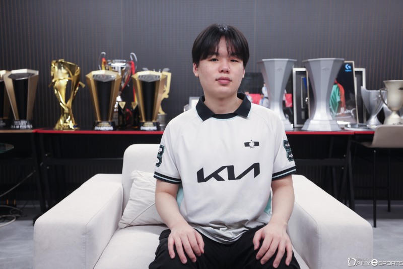 트로피가 있는 실내에서 디플러스 기아 유니폼을 입고 앉은 스매쉬 신금재